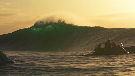 Orange-light-shines-on-empty-crashing-big-wave-with-ocean-mist-spray-and-surfers