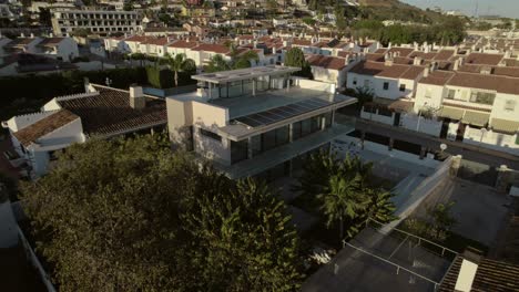 Aerial-droneshot-of-a-modern-house-in-Malaga,-Spain---some-streets-and-the-city-behind