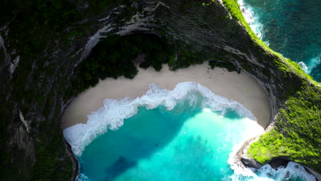 Drone-top-down-rising-above-Kelingking-sandy-cove-with-turquoise-blue-water-Bali