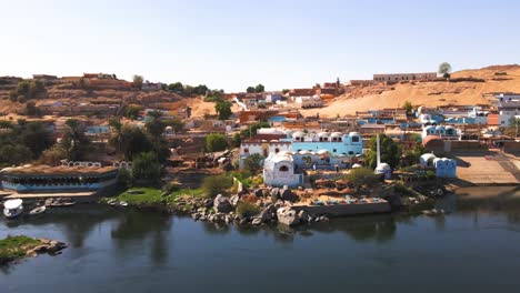 Aerial-of-the-Nubian-village-on-the-Nile-River-,-traditional-Egyptian-sailing-boats,-in-Aswan,-Egypt,-embodying-the-concept-of-timeless-maritime-heritage-and-cultural-richness