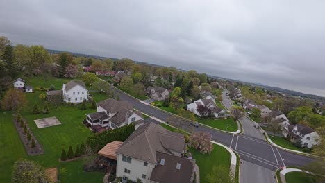 FPV-Drohnenaufnahme-Von-Einfamilienhäusern-Auf-Der-Straße-In-Einem-Amerikanischen-Vorort-Mit-Fahrendem-Auto