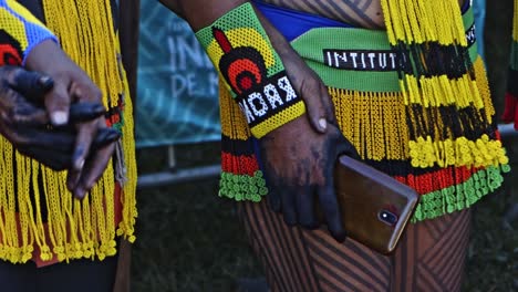 Indigenous-amazonian-people-in-traditional-dresses-holding-a-cellphone