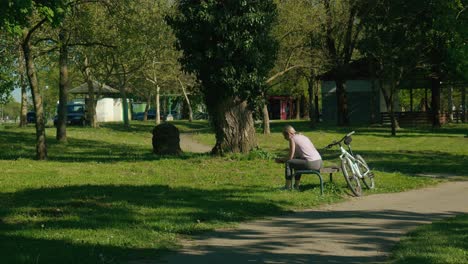 Momento-De-Tranquilidad-Junto-Al-Lago-Jarun-En-Zagreb,-Con-Una-Persona-Descansando-En-Bicicleta