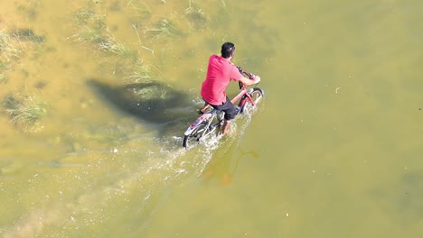 On-April-23,-2024,-a-cyclist-navigated-through-a-flooded-road-in-the-northern-Emirates-of-the-UAE-following-record-breaking-rains-in-the-country