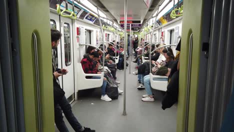 Argentina,-Buenos-aires-people-look-at-devices-inside-underground-train-railway-of-Line-A,-Plaza-de-Mayo-to-Flores-Station