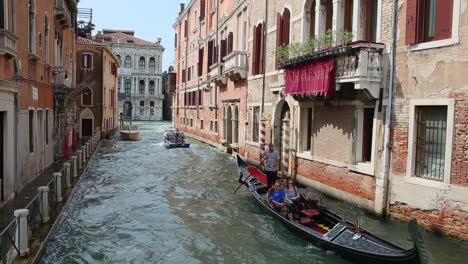 Tourist-enjoy-romantic-ride-on-traditional-Venetian-gondola-on-sunny-summer-day