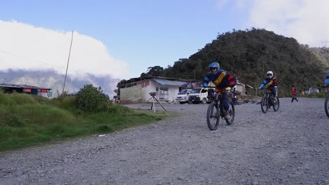 Tourist-group-rides-full-suspension-mountain-bikes-down-mountain-road