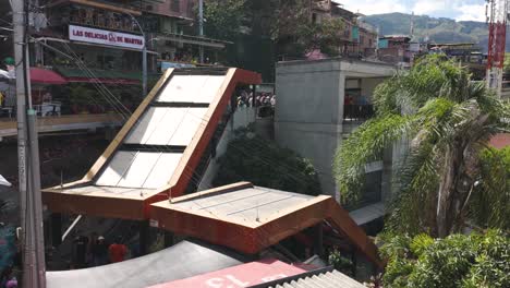 Urban-innovation-with-Comuna-13's-escalators-among-bustling-neighborhood-life,-Medellin-Colombia