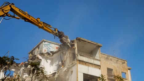 An-excavator-tearing-down-an-encroachment-building-under-a-clear-sky
