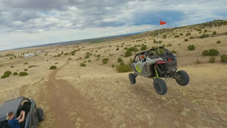 Luftbild-FPV-Verfolgt-ATV-Sprünge-über-Wüstenlandschaft-In-Arizona