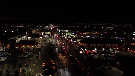 Las-Vegas-USA-at-Night,-Flying-Above-Chinatown,-Street-Traffic-and-Buildings-in-Lights