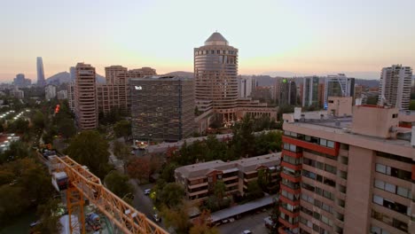 Drone-flyover-through-construction-crane-toward-to-Mandarin-Oriental-Hotel-in-Las-Condes,-Santiago,-Chile