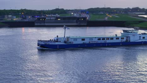 Prinses-Maxima-Ship-Cruising-Through-The-River-In-Alblasserdam,-Netherlands---Drone-Shot
