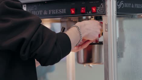 Hand-pouring-kernels-into-a-traditional-popcorn-machine-for-fresh-popping