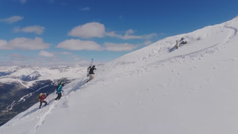 Group-of-mountain-climber-reaching-summit-cross-of-snowy-Cima-di-Cece-Mountain-in-Italy