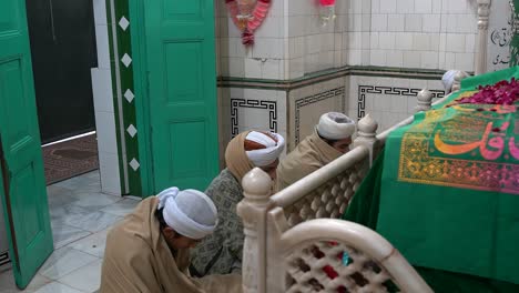 Jóvenes-Recitando-El-Corán-En-El-Santuario-Shah-Dola-En-Gujrat,-Pakistán,-Mostrando-Un-Profundo-Compromiso-Religioso