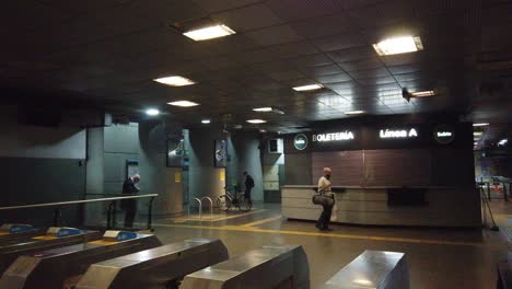 Underground-subway-station-of-buenos-aires-city-argentina-people,-metallic-Turnstile-and-closed-ticket-store,-elder-senior-citizens-walking