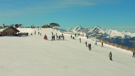 Skiers-gliding-on-snowy-slopes-at-Flaine-ski-resort-in-French-Alps-on-a-sunny-day,-wide-shot
