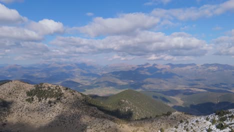 Hermoso-Cielo-Azul-Con-Nubes-Largas-Y-Esponjosas-Que-Proyectan-Sombras-Sobre-Las-Montañas-Del-Valle-Del-Peloponeso