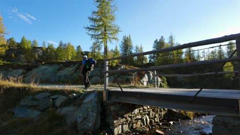 Männlicher-Wanderer-Zu-Fuß-über-Die-Brücke-In-Der-Region-Valmalenco,-Italien