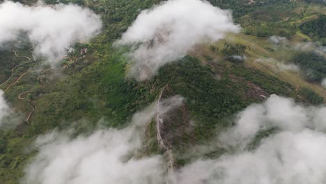 Impresionante-Vista-Aérea-De-La-Montaña-Katusu-Konda-De-Sri-Lanka-Al-Amanecer,-Mostrando-Una-Exuberante-Vegetación,-Arenas-Anaranjadas,-Caminos-Sinuosos-Y-Nubes-Ondulantes-Bajo-Un-Cielo-Azul-Claro.