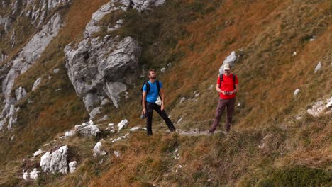 Luftaufnahme-Von-Zwei-Männlichen-Wanderfreunden-Auf-Einem-Bergkamm,-Die-Sich-Selbst-Mit-Einer-Drohne-In-Den-Lecco-Alpen-Filmen