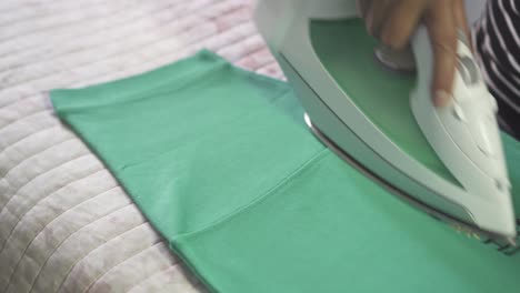 Young-Latin-woman-ironing-a-green-shirt