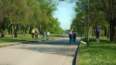 Sunny-day-at-Jarun-Lake,-Zagreb,-with-people-strolling-and-enjoying-outdoor-activities