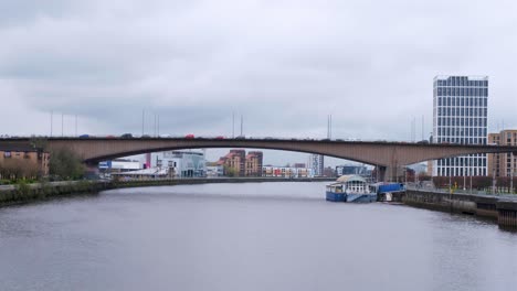 Starker-Verkehr-über-Die-Brücke-Und-Den-Fluss-Clyde,-Gesäumt-Von-Gebäuden,-Geschäften-Und-Bürohochhäusern-In-Der-Stadt-Glasgow,-Schottland,-Großbritannien