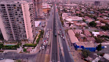Dolly-in-flyover-tracking-the-Santiago-de-Chile-subway-car-with-tracks-over-the-road,-Chile