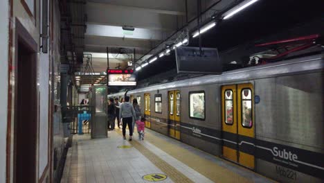 Una-Familia-Camina-Afuera-De-La-Estación-De-Metro-De-La-Ciudad-De-Buenos-Aires,-El-Tren-Sale