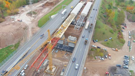 Pushing-bridge-frame-over-construction-site-in-Kaunas,-Lithuania,-aerial-view