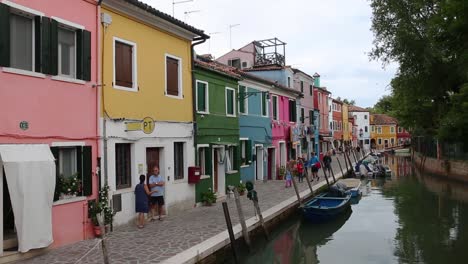 Family-on-tour-sightseeing-vivid-district-of-colourful-houses-on-Burano-Island,-Venice,-Italy