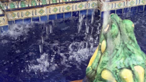 Water-splashes-over-the-Pescaito-Fountain-in-Plaza-de-España,-the-central-square-of-Vejer-de-la-Frontera,-Cadiz,-Andalusia,-Spain,-creating-a-playful-atmosphere-reminiscent-of-a-fun-park