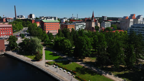Drone-circling-the-Koskipuisto-park,-sunny,-summer-day-in-Tampere,-Finland