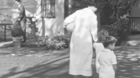 Kindermädchen-In-Uniform-Kümmern-Sich-In-Den-1930er-Jahren-Um-Kinder,-Die-Im-Garten-Eines-Hauses-Spielen