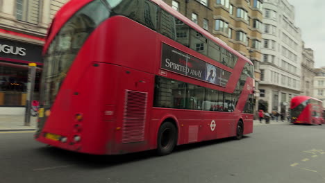 London-Bus-rounds-corner-onto-The-Haymarket,-London,-Day