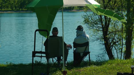 Ein-älteres-Ehepaar-Genießt-Einen-Ruhigen-Angeltag-Unter-Sonnenschirmen-Am-Ruhigen-Wasser-Des-Jarun-Sees