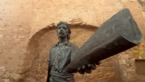 The-statue-commemorating-Juan-Relinque,-situated-close-to-the-Puerta-de-Sancho-IV-in-Vejer-de-la-Frontera,-Cádiz,-Spain,-highlights-the-abundant-history-and-heritage-of-the-region