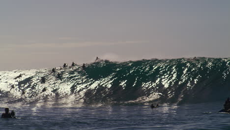 Vista-Panorámica-De-Surfistas-En-Fila-Intentando-Atrapar-Olas-Monstruosas.