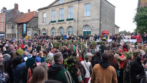 Public-performance-with-crowds-of-people-watching-during-Beltane-May-Day-celebrations-in-Glastonbury-town,-Somerset-UK