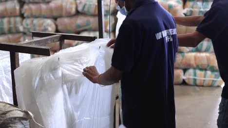 pov-shot-bags-of-food-packed-into-small-bags-being-systematically-packed-into-larger-bags-by-humans