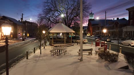 Centro-De-La-Plaza-De-La-Ciudad-Cubierto-De-Nieve-Durante-El-Atardecer-De-Invierno,-Al-Anochecer