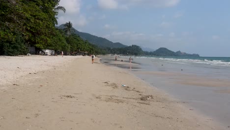 Tiefflug-Entlang-Des-Weißen-Sandstrandes-Von-Koh-Chang-Mit-Touristen,-Die-Den-Tag-Genießen