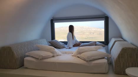 Woman-look-outside-the-window-on-exotic-arc-ceiling-bedroom-in-Italy