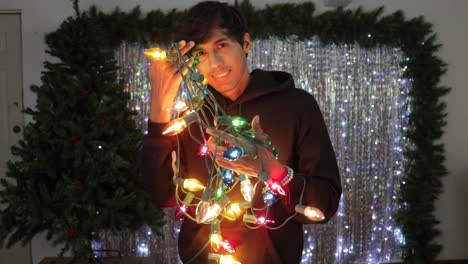 Happy-hispanic-man-preparing-for-Christmas-season-with-light-decorations