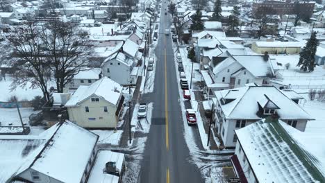 Aerial-above-town-main-street-during-winter-snow