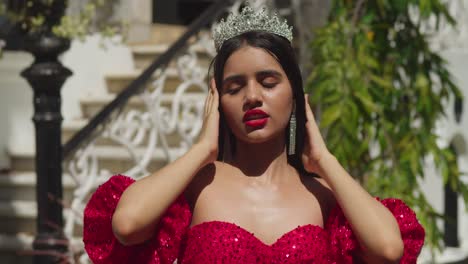 Amidst-the-whispers-of-history-in-a-Caribbean-castle,-a-young-lady-elegantly-stands-in-her-striking-red-gown-facial-close-up