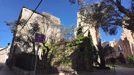 Son-Servera's-never-finished-church,-entrance-from-the-street-to-the-first-look-to-limestone-on-blue-sky-backdrop