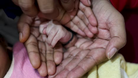 Neugeborenes-Hand-Willkommen-Mit-Anderen-Familienmitgliedern-Hand-Zu-Hause